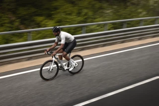 Mann fährt mit Rennrad auf einer Straße