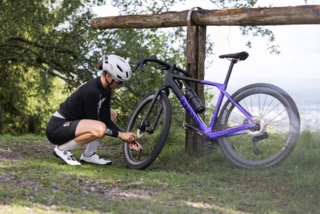 Frau pumpt Reifen am Gravelbike mit Minipumpe auf