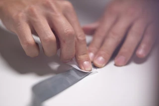Someone is cleaning a TPU hose with a cloth